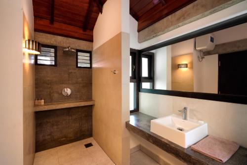 a bathroom with a sink and a mirror at Seven Turtles in Tangalle