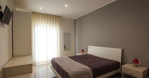 a bedroom with a bed and a large window at Matera Sassi Rooms 21/a e 21/b in Matera