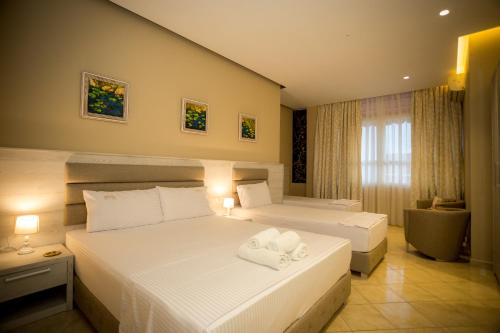 a hotel room with two beds and a window at Hotel Valz in Velipojë