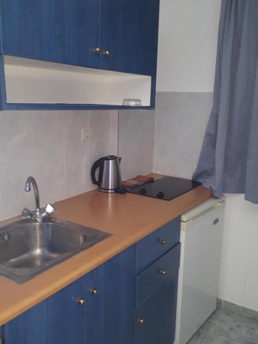 a kitchen with a sink and a counter top at Roula Villa Studios & Apartments in Perissa
