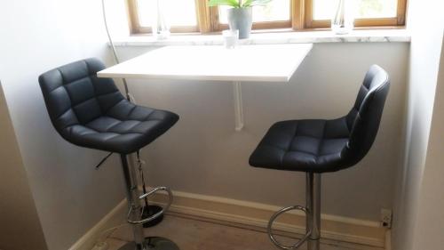 two black chairs sitting next to a white table at B&B Holme-Olstrup in Holme-Olstrup