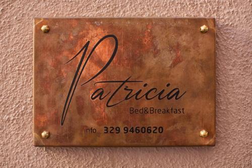 a rusty sign on a wall with the name of a hotel at PATRICIA BED&BREAKFAST in Patrica