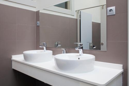 a bathroom with two sinks and a mirror at Malaga Stop Hostel AB in Málaga