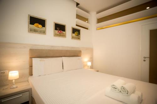 a bedroom with a white bed with towels on it at Hotel Valz in Velipojë