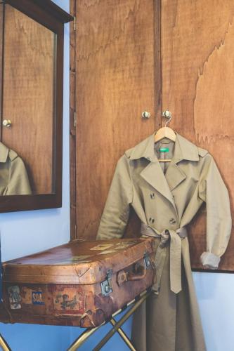 a trench coat and a suitcase on a shelf at Hotel Il Giardino in Siena