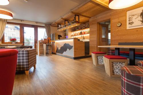 un restaurante con suelo de madera y sillas rojas en Hotel Vallée Blanche Courmayeur, en Courmayeur