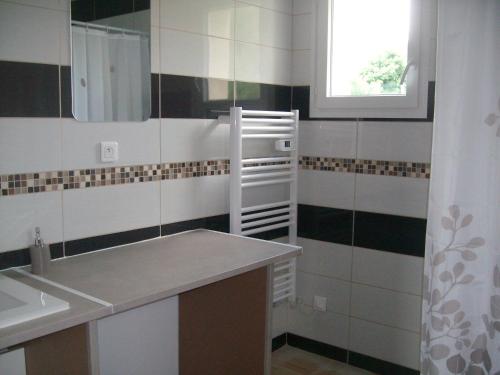 ein Badezimmer mit Waschbecken und Spiegel in der Unterkunft M. Clemenceau - Les Maisonnettes De La Maneliére in La Flocellière