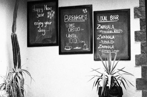 a group of signs on a wall with plants at African Rock Lodge in Hoedspruit