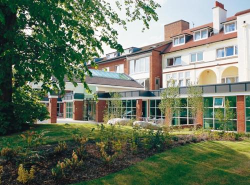 a building with a lawn in front of it at Regency Park Hotel, Health Club & Spa in Newbury
