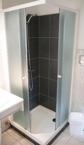 a shower with a glass door in a bathroom at Hôtel Les Frangins in Saint-Omer