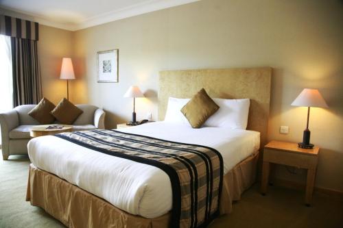 a hotel room with a large bed and a couch at Regency Park Hotel, Health Club & Spa in Newbury