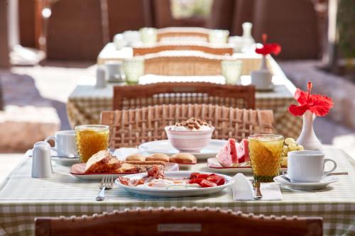 Una mesa cubierta con platos de comida y bebidas. en Santo Miramare Beach Resort, en Perivolos
