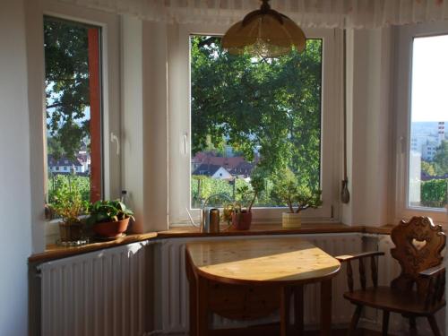 una cucina con tavolo e due grandi finestre di Blum Ferienwohnung a Costanza
