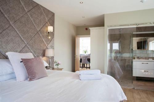 a bedroom with a large white bed and a kitchen at Black Horse Beamish in Stanley
