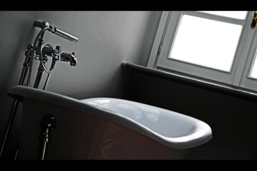 a bathroom with a white sink and a window at La Ribezza Boutique Hotel in Monforte dʼAlba