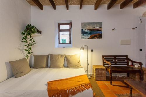 a bedroom with a bed and a chair and a window at Casa Ana in Ses Salines
