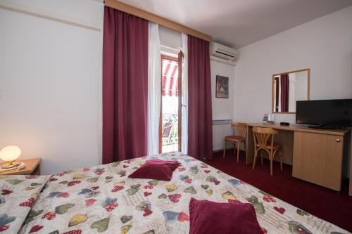 a bedroom with a bed and a desk and a window at Bed & Breakfast Villa Klara in Ičići