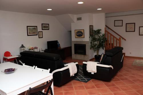 a living room with black furniture and a fireplace at Casa Paz do Outeiro in Paredes de Coura