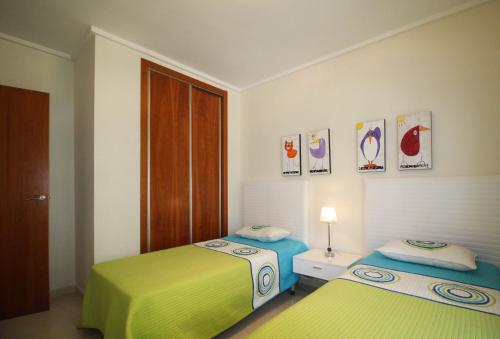 a bedroom with two beds and a door at Cosy Cwtch 2 in Los Alcázares