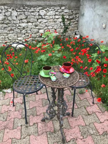 a table with two chairs and two cups on at Gîte du Parc des Mauves in Meung-sur-Loire