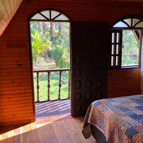 an open room with a bed and an open door at Chalé Dei Fiori, 3QTS, Ambiente Ideal para a família in Venda Nova do Imigrante