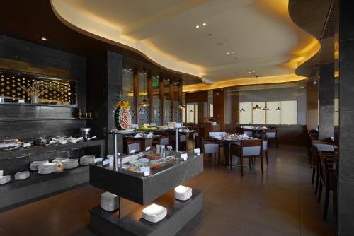 巴罗达The Fern, Vadodara的有桌椅和自助餐的餐厅