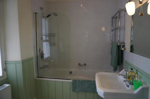 a bathroom with a sink and a shower and a tub at Minton House in Colyton