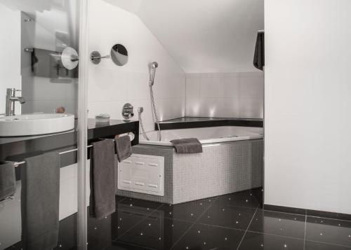 a bathroom with a tub and a sink at Hotel Metzgern in Sarnen