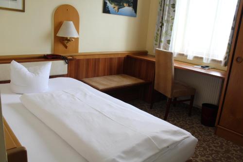 a bedroom with a bed and a desk and a chair at Hotel Wachau in Melk