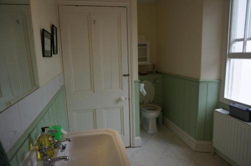 a bathroom with a toilet and a sink and a door at Minton House in Colyton