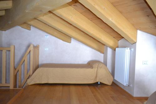 una camera da letto con letto in mansarda con soffitti in legno di Casa Vacanza La Rocca a Chiesa in Valmalenco