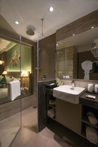 un baño con lavabo y ducha en The Fern, Vadodara, en Vadodara