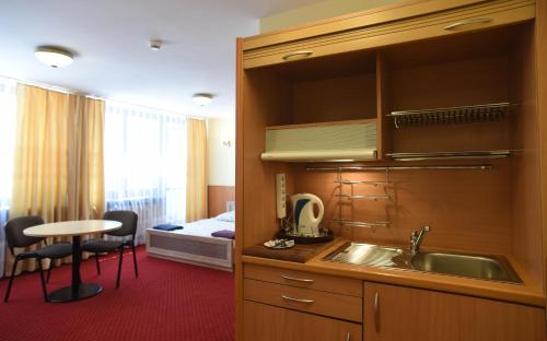 a kitchen with a sink and a bed in a room at Dobre Miejsce Dom Rekolekcyjny in Warsaw