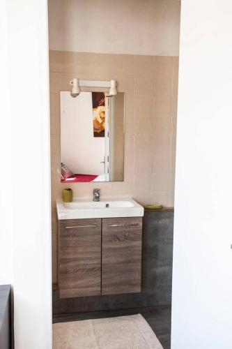 une salle de bain avec un lavabo et un miroir dans l'établissement Le Piano par Dodo-a-Cassis, à Cassis