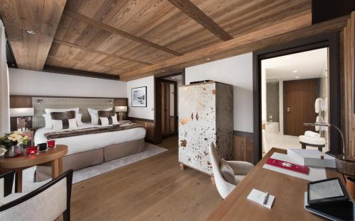 a bedroom with a bed and a desk in a room at Hôtel Barrière Les Neiges Courchevel in Courchevel