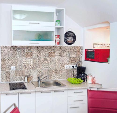 a kitchen with a sink and a red microwave at ★ 2 minute walk from the Bridge of Lies ★ in Sibiu