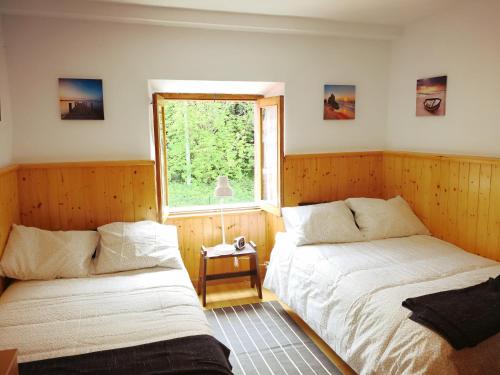 two beds in a room with a window at Casafer in Naves