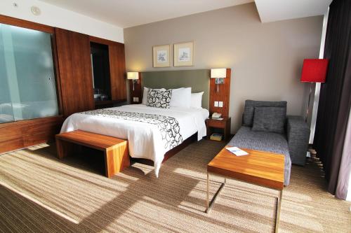 Habitación de hotel con cama y sofá en Casa Inn Premium Hotel Queretaro, en Querétaro