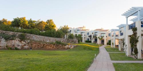a walkway in a park next to houses at Bimbolla Apartaments in Punta Prima