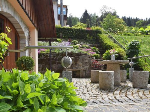 a garden with a fountain and some plants and a building at Quaint Farmhouse in Langenbach near the Lake in Langenbach