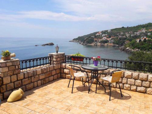 eine Terrasse mit einem Tisch, Stühlen und Meerblick in der Unterkunft Apartments Antigona Old Town in Ulcinj