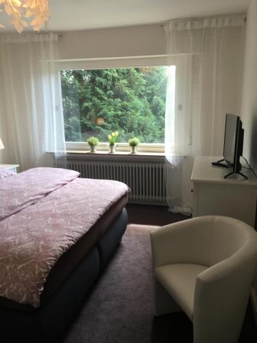 ヴィルヘルムスハーフェンにあるApartement "Sam"のベッドルーム1室(ベッド1台、椅子、窓付)