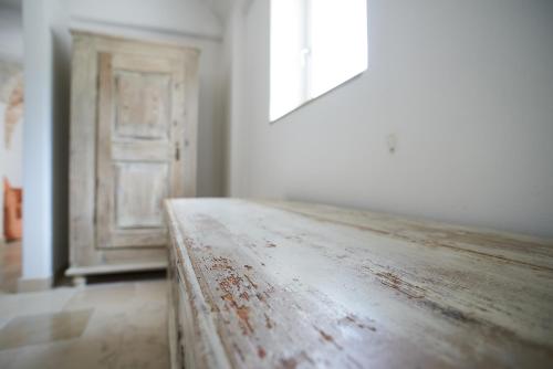 a wooden table sitting in front of a door at Trullidea in Alberobello