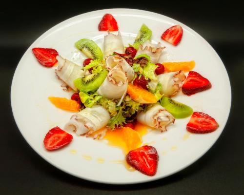 a white plate of food with fruit on it at Hotel Spa El Muelle de Suances in Suances