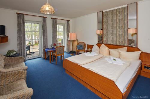 a hotel room with a large bed and a couch at Seeblick in Mühbrook
