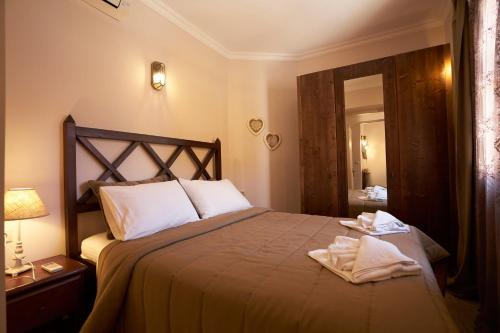 a bedroom with a bed with two towels on it at Kaminos Boutique Hotel in Symi