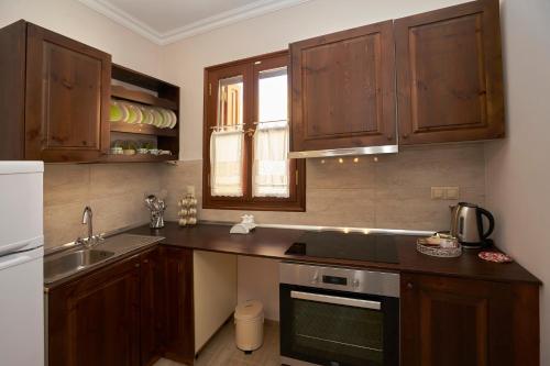 a kitchen with wooden cabinets and a sink at Kaminos Boutique Hotel in Symi