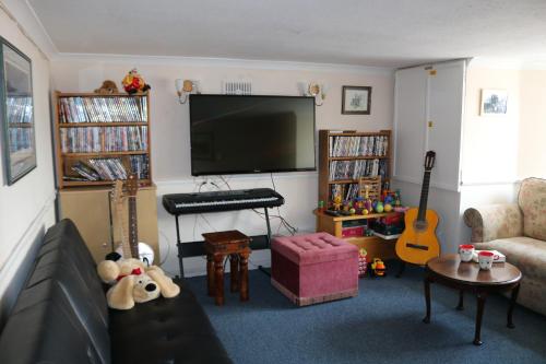 sala de estar con sofá y TV de pantalla plana en Littlestone Hotel en New Romney