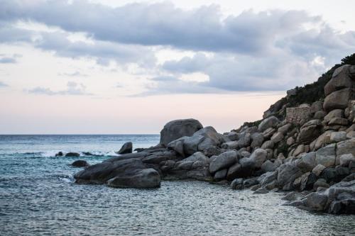 a group of rocks on the shore of the ocean at Hotel Solanas in Solanas
