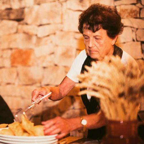 a man in an apron cutting a plate of food at Trulli Panoramici in Alberobello